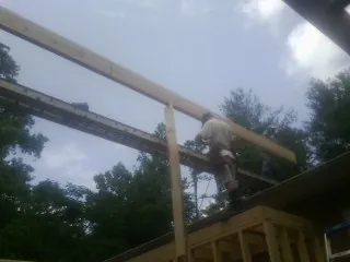 Carpenter setting a ridge beam over a new addition frame — Ice Dam Removal by Roofing Brothers in Martinsville